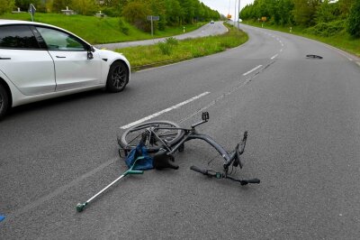 77-jähriger Radfahrer stirbt nach Unfall auf B6 in Leipzig - Ein beschädigtes Fahrrad liegt nach einem Unfall auf der B6 neben einem Auto.