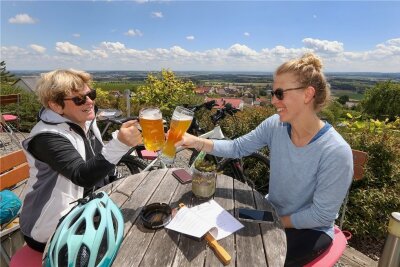 Prost! Mutter und Tochter machen während einer Radtour Halt in einem Biergarten in Uttenweiler-Offingen in Baden-Württemberg. 