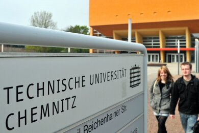 Studenten gehen am zentralen Hörsaalgebäude der Technischen Universität Chemnitz vorüber.