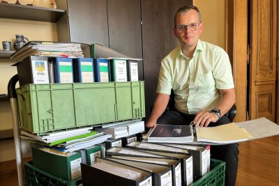 Tobias Keller in seinem Büro mit einem ganzen Wagen voller Akten zum Thema Bundeskältekompetenzzentrum.