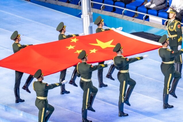 Auch die Ausrichtung der Olympischen Winterspiele nutzt China, um sich als offen autoritärer Staat im Konzert der Weltmächte zu präsentieren: Chinesische Soldaten bringen die Flagge der Volksrepublik ins Olympiastadion in Peking. 