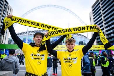 Zwei Fans von Borussia Dortmund stehen mit einem BVB-Fan-Schal vor dem Wembley-Stadion.