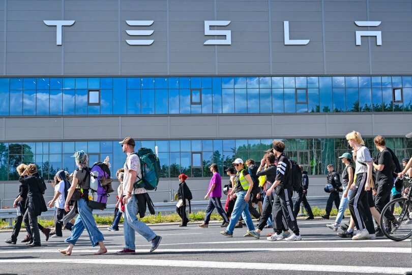 Teilnehmer einer Protestveranstaltung gehen zum Werk von Tesla in Grünheide in Brandenburg.