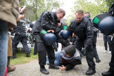 Polizeibeamte gehen während propalästinensischen Demonstration der Gruppe "Student Coalition Berlin" auf dem Theaterhof der Freien Universität Berlin gegen Demonstranten vor.