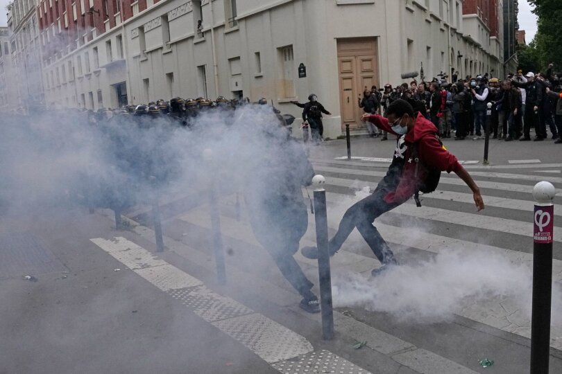 Voller Wut: Französische Demonstranten werfen während einer Kundgebung einen Kanister mit Tränengas. Im ganzen Land protestiert ein breites Bündnis aus Gewerkschaften, Parteien und Organisationen gegen das Erstarken der extremen Rechten.