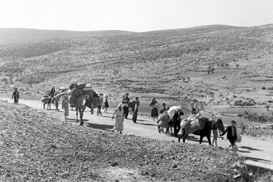 Arabische Flüchtlinge gehen mit ihren Kindern und Habseligkeiten im Gepäck am 9. November 1948 auf einer staubigen Straße von Jerusalem in den Libanon. Die Staatsgründung Israels war 1948 für Hunderttausende von Palästinensern mit Vertreibung und dem Verlust von Heimat verbunden.