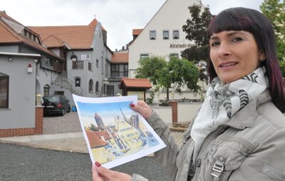 850 Jahre Freiberg: Hotelbranche profitiert von den Feierlichkeiten - Christine Walcha führt das neue Altstadt-Hotel an der Donatsgasse in Freiberg. Hier hält sie eine historische Aufnahme von dem Haus, die auch als Ansichtskarte erhältlich ist.