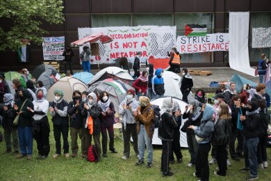 Teilnehmerinnen und Teilnehmer stehen während einer propalästinensischen Demonstration der Gruppe "Student Coalition Berlin" auf dem Theaterhof der Freien Universität Berlin.