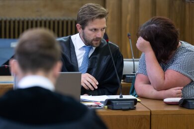Hinter dem Staatsanwalt unterhalten sich die im sogenannten "Fahrradgate"-Skandal angeklagte Frau und ihr Verteidiger Erik Bergmüller im Landgericht Leipzig.