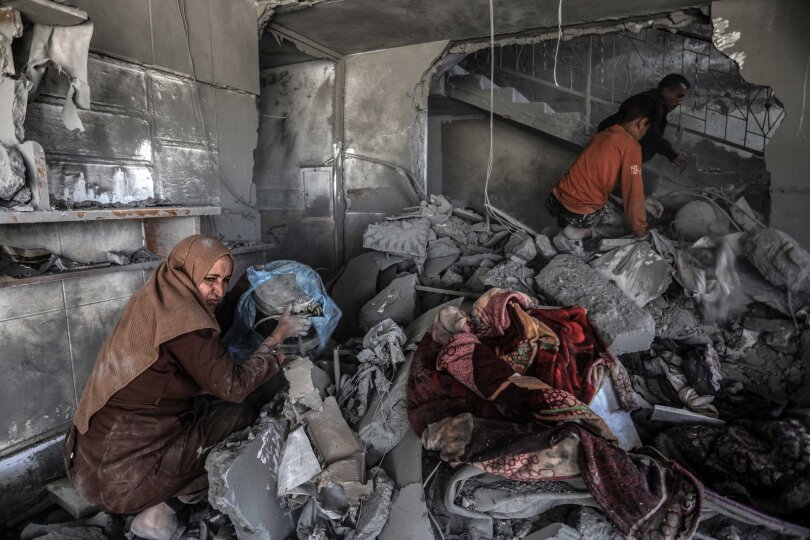 Nach einem israelischen Luftangriff such Palästinenser in einem zerstörten Haus nach Habseligkeiten.