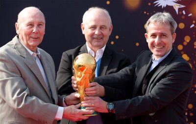 90 Minuten für die Ewigkeit - Die ehemaligen Fußball-Nationalspieler und Weltmeister Horst Eckel, Bernd Hölzenbein und Pierre Littbarski mit der originalen Fifa WM-Trophäe.