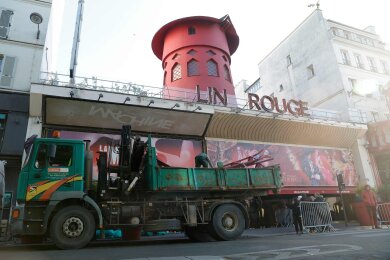 Arbeiter sichern den Bereich vor dem Kabarett, nachdem die Flügel des Windrads des "Moulin Rouge" in der Nacht abgestürzt sind.