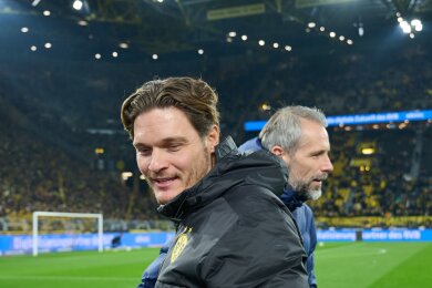 Dortmunds Trainer Edin Terzic (l) und Trainer Marco Rose gehen vor dem Spiel am Spielfeldrand entlang.