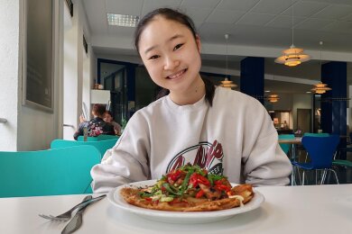 In freudiger Erwartung: Yuria Takahashi vor ihrem Okonomiyaki-Teller in der Hochschulmensa am Dr.-Friedrichs-Ring.