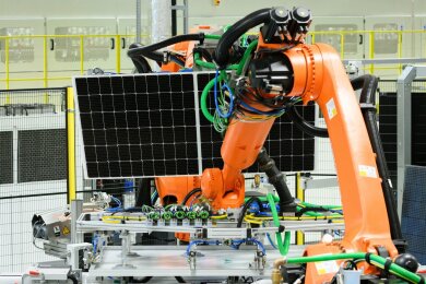 Ein Solarmodul wird in der Produktionslinie im Werk der Solarwatt GmbH mit einem Roboter zum nächsten Arbeitsgang transportiert.