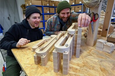 Sie haben das Spielen definitiv nicht verlernt: David Müller (links) und Tino Hartrampf mit einer ihrer Murmelbahnen in der Werkstatt ihrer Firma "Baumkinder".  