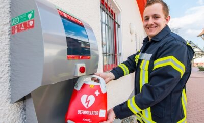 Notfallsanitäter Tim Ostenhausen kann zufrieden lächeln: Nun befindet auch am Adorfer Feuerwehrgebäude ein Defibrillator. 