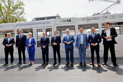 Gruppenbild vor Tatra-Straßenbahn: Kai Wegner aus Berlin (v.l.n.r.), Dietmar Woidke aus Brandenburg, Manuela Schwesig aus Mecklenburg-Vorpommern, Bundeskanzler Olaf Scholz, Michael Kretschmer, Reiner Haseloff aus Sachsen-Anhalt, Bodo Ramelow aus Thüringen, der Ostbeauftragte Carsten Schneider und Staatssekretär Michael Kellner.