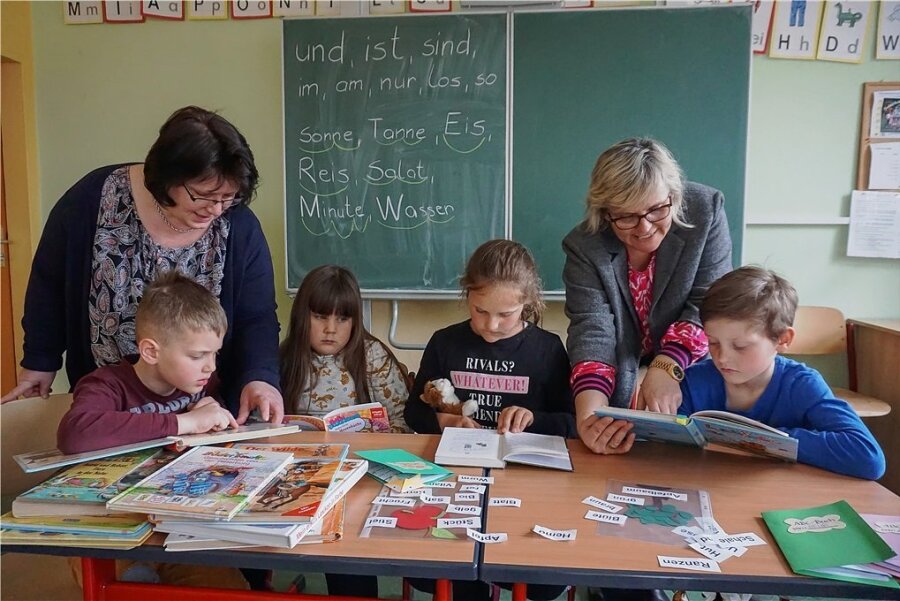 Maria Langenegger (li.) hilft Helge, Alina, Juna und Phil aus Bad Brambach beim Lesenlernen. Schulleiterin Annett Stahl ist froh, dass sie sie dafür gewinnen konnte. 