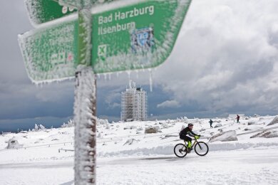 Ein Radfahrer ist auf dem schneebedeckten Brocken unterwegs.