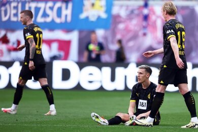 Dortmunds Nico Schlotterbeck (M) reagiert neben seinen Teamkollegen Marco Reus (l) und Julian Brandt.