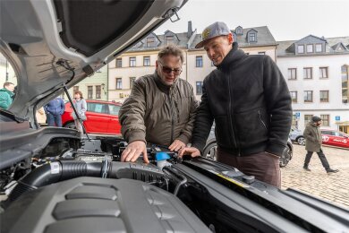 Udo Kraus (links) vom Autohaus Zeidler aus Mylau blickt mit Fabian Krause unter die Motorhaube eines Skoda.