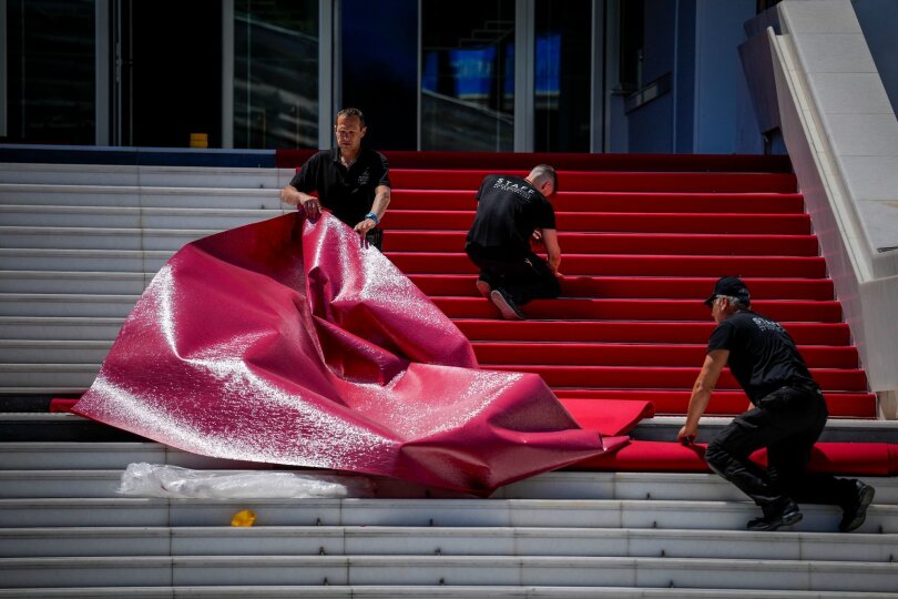 Mitarbeiter legen den roten Teppich am Palais de Festival für das 77. internationale Filmfestival in Cannes aus. Das Filmfestival findet vom 14. bis 25. Mai 2024 statt.