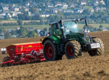 Ein Olbernhauer Landwirtschaftsbetrieb sät mit Traktor und angehängter Drillmaschine Getreide aus.