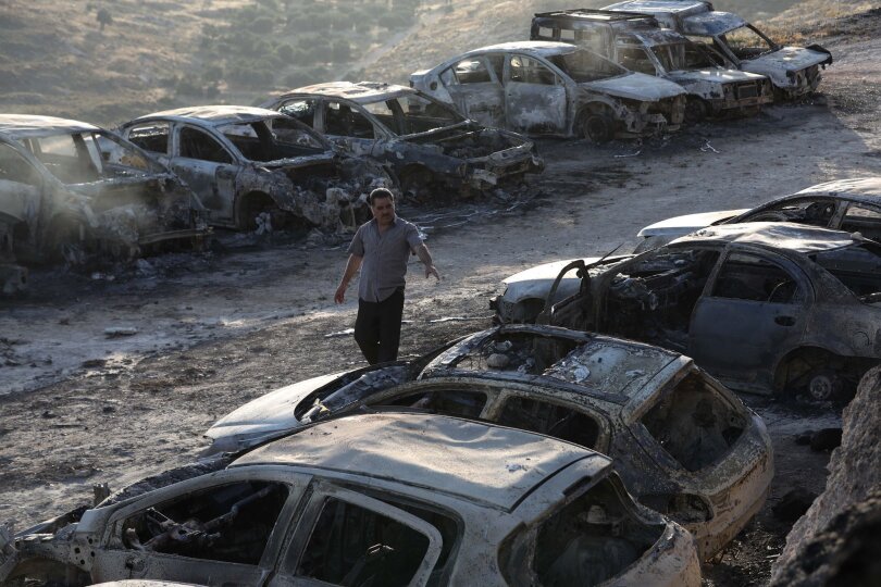 Ein Mann blickt auf verbrannte Autos nach einem israelischen Angriff im Dorf Burqa im Westjordanland.