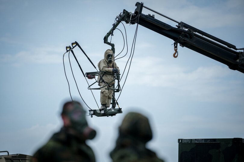 Training für den Ernstfall: Ein Bundeswehrsoldat in ABC-Schutzausrüstung hängt an einem Kran auf einem Truppenübungsplatz im litauischen Pabrade. Unweit der Nato-Ostflanke findet derzeit das mehrmonatige Quadriga-Manöver der Bundeswehr statt.