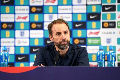 Englands Nationaltrainer Gareth Southgate sitzt während einer Pressekonferenz auf dem Podium.