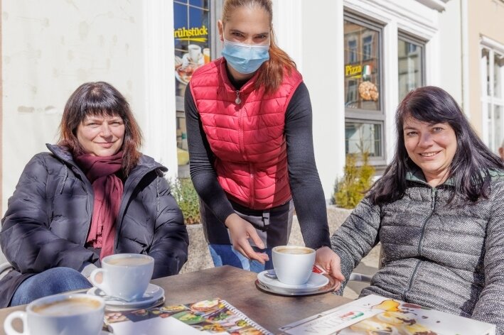 Ab an die frische Luft! - Die Außenbereiche der Cafés wie im "Cortina" am Annaberger Markt füllen sich. Anamaria Neagu (Mitte) versorgt Gäste mit Heißgetränken.