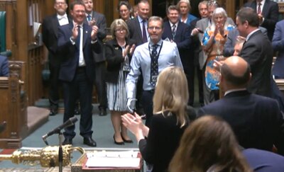 Abgeordneter kehrt nach Amputationen zurück - Der konservative Abgeordente Craig Mackinlay (m.) wird bei seiner Rückkehr von den Mitgliedern des Parlaments beklatscht.