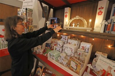 Advent im Dom zu Freiberg: Geschenke, Kerzen, Kunstgenuss - Viola Strähle vom Domladen in Freiberg bestückt das Weihnachtsregal.