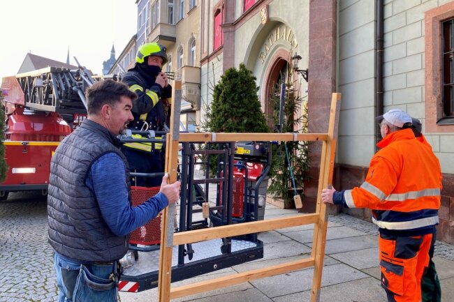 Feuerwehrchef René Schröter und Mitarbeiter des Bauhofs der Stadt Mittweida haben am Mittwochmorgen mit der Drehleiter das Türchen mit der Nummer 24 am Rathaus montiert.