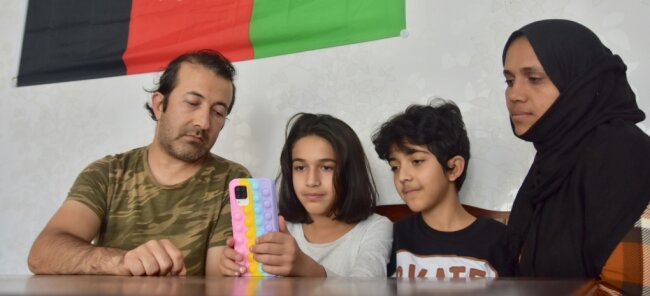 Afghanen und die Angst um die Familie - Assadullah (links) und Media Khaleqian (rechts) mit zwei ihrer insgesamt fünf Kinder, Ruhalla (Mitte rechts) und Fatima. Sie schauen sich täglich im Internet Nachrichten und Videos über den Zustand ihres Heimatlandes an, seitdem die Taliban dort die Macht ergriffen haben. 