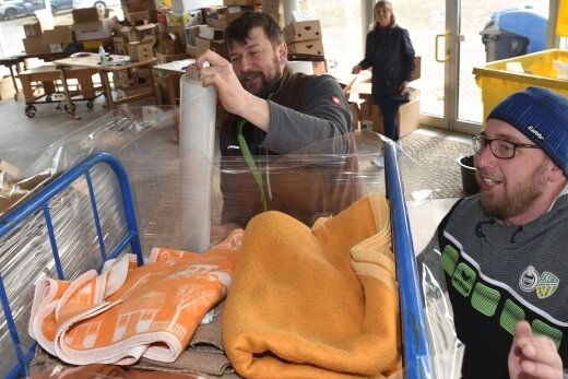 Aktion soll Lastzug mit Spenden für Ukraine füllen - In Thum und Gelenau ist eine Spendenaktion für die vom Krieg betroffenen Menschen in der Ukraine angelaufen. Hermann Einenkel und Robby Schmidt (vorn von links) verpacken eine Palette mit Decken. 