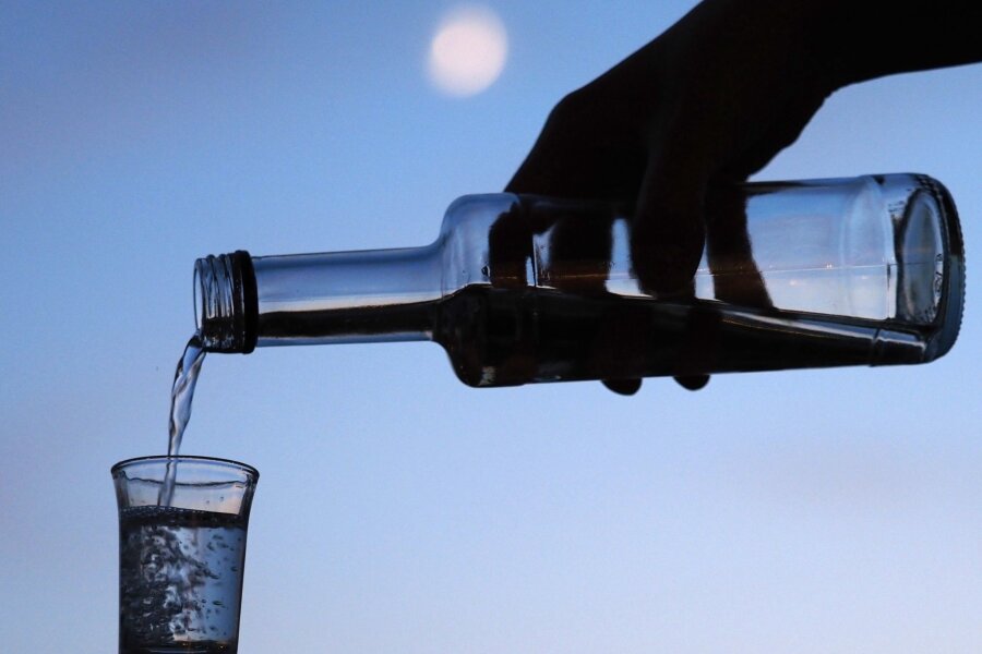 Alkohol bleibt drängendstes Problem in Suchtberatungsstellen - Ein Mann gießt am Abend aus einer Flasche Schnaps in ein Glas. Alkohol bleibt in Sachsens Suchtberatungsstellen das häufigste Thema.
