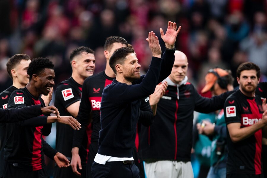 Alonso über Bayern-Niederlage: "Zwei Siege an einem Tag" - Leverkusens Trainer Xabi Alonso (M) und seine Spieler feiern den Sieg gegen die  die TSG 1899 Hoffenheim.