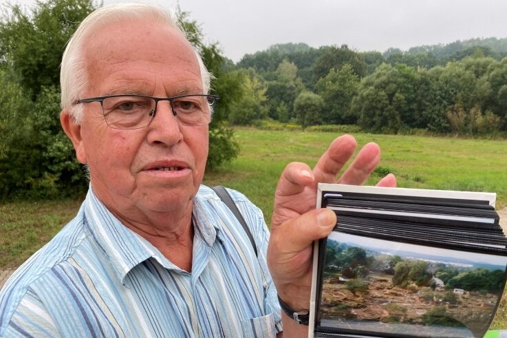 Als Kleingärten in Flöha verschwanden - Peter Richter mit seinen Fotos vom Hochwasser. Auf der Fläche hinter ihm befand sich die Kleingartenanlage "Sonneninsel". 