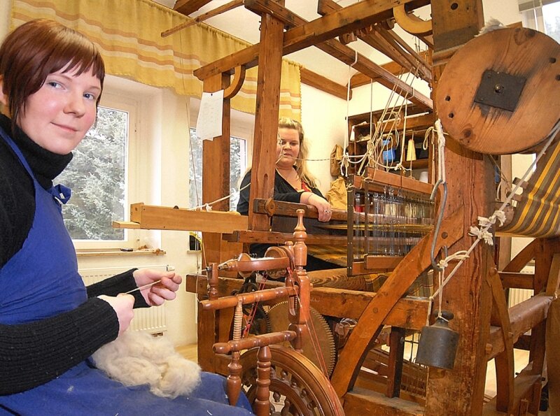 Alte Techniken leben wieder auf - 
              <p class="artikelinhalt">Während Diana Flach (22, l.) am Spinnrad Wolle zu Garn werden lässt, webt Madlen Reichard (23) an einem 200 Jahre alten Webstuhl Stoffbahnen. Die Textilwerkstatt arbeitet beim Erwerb von handwerklichem Wissen auch mit dem Web-Museum in Oederan zusammen. </p>
            