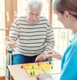 Altenpflege: Freiwillige als Notfallreserve - Freiwillige Helfer haben - wie auf diesem Symbolbild - oft Zeit für Gesellschaftsspiele, Vorlesen oder andere Angebote der sozialen Teilhabe. Bei Personalnot sollen sie auch Pflegekräfte unterstützen. 