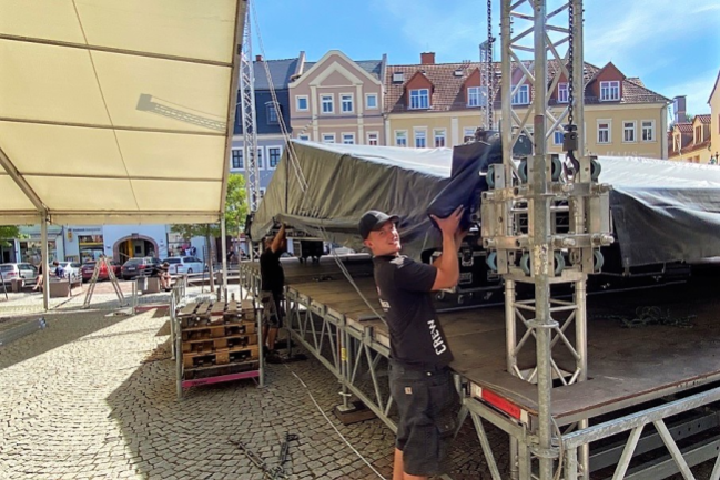 Bühnenbauer Henry Sullivan von der Firma Wonneberger Bühnen- und Veranstaltungstechnik hilft am Mittwoch, das Dach für die Bühne auf dem Markt aufzubauen.