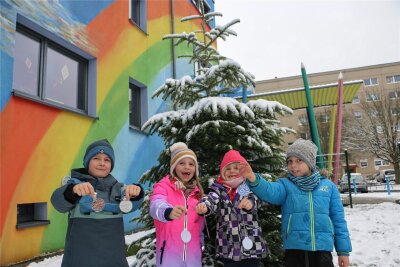 Am Chrieschwitzer Hang in Plauen leuchtet es im Advent - Lenny, Ida, Nora und Tarek (von links) gehören zu den Kindern, die den Weihnachtsbaum vor der Evangelischen Montessori Grundschule schmückten.