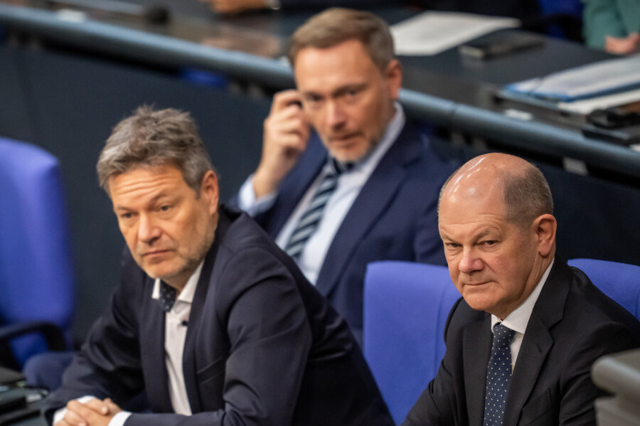 Ampel-Koalition erzielt Durchbruch bei Haushaltsgesprächen - Olaf Scholz (SPD, r), verfolgt neben Robert Habeck (Bündnis 90/Die Grünen, l), Bundesminister für Wirtschaft und Klimaschutz, und Christian Lindner (FDP), Bundesminister der Finanzen, die Debatte zur Haushaltslage im Bundestag.