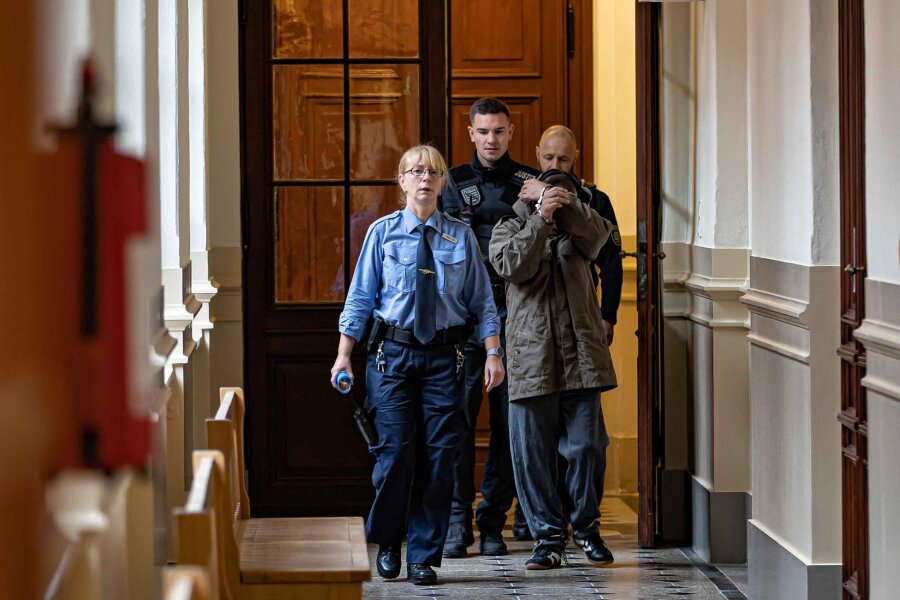 Angriff mit Todesfolge in Reichenbach: 49-jähriger Mann angeklagt - Der 49-jährige Angeklagte wurde, an Händen und Füßen gefesselt, zur Verhandlung aus der Untersuchungshaft vorgeführt.