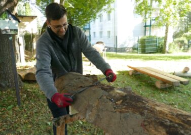 Arbeitslose halten Zschopauer Wanderwege in Schuss - Marcus Gillner entrindet eine Baumstammhälfte. Daraus fertigen AGH-Teilnehmer Bänke, die an Wanderwegen um Zschopau aufgestellt werden. 
