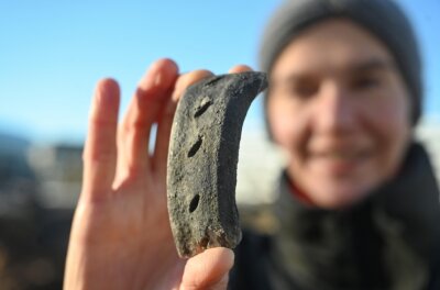 Archäologen melden älteste Funde bei Grabungen in Chemnitz - Grabungsleiterin Nicole Eichhorn zeigt eines der Fundstücke aus der Vergangenheit, das auf dem alten Parkplatz im Stadtzentrum entdeckt wurde. 