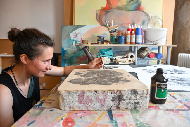Vivien Nowotsch malt in ihrem Atelier mit spezieller Tusche auf einen Lithostein. 