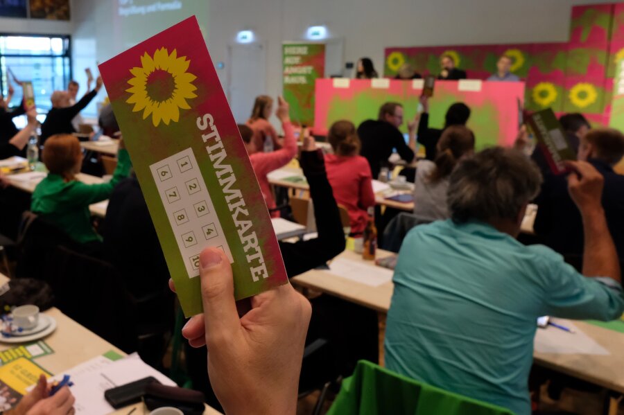  Delegierte der Landesversammlung der sächsischen Grünen halten am Samstag Stimmkarten in die Höhe.